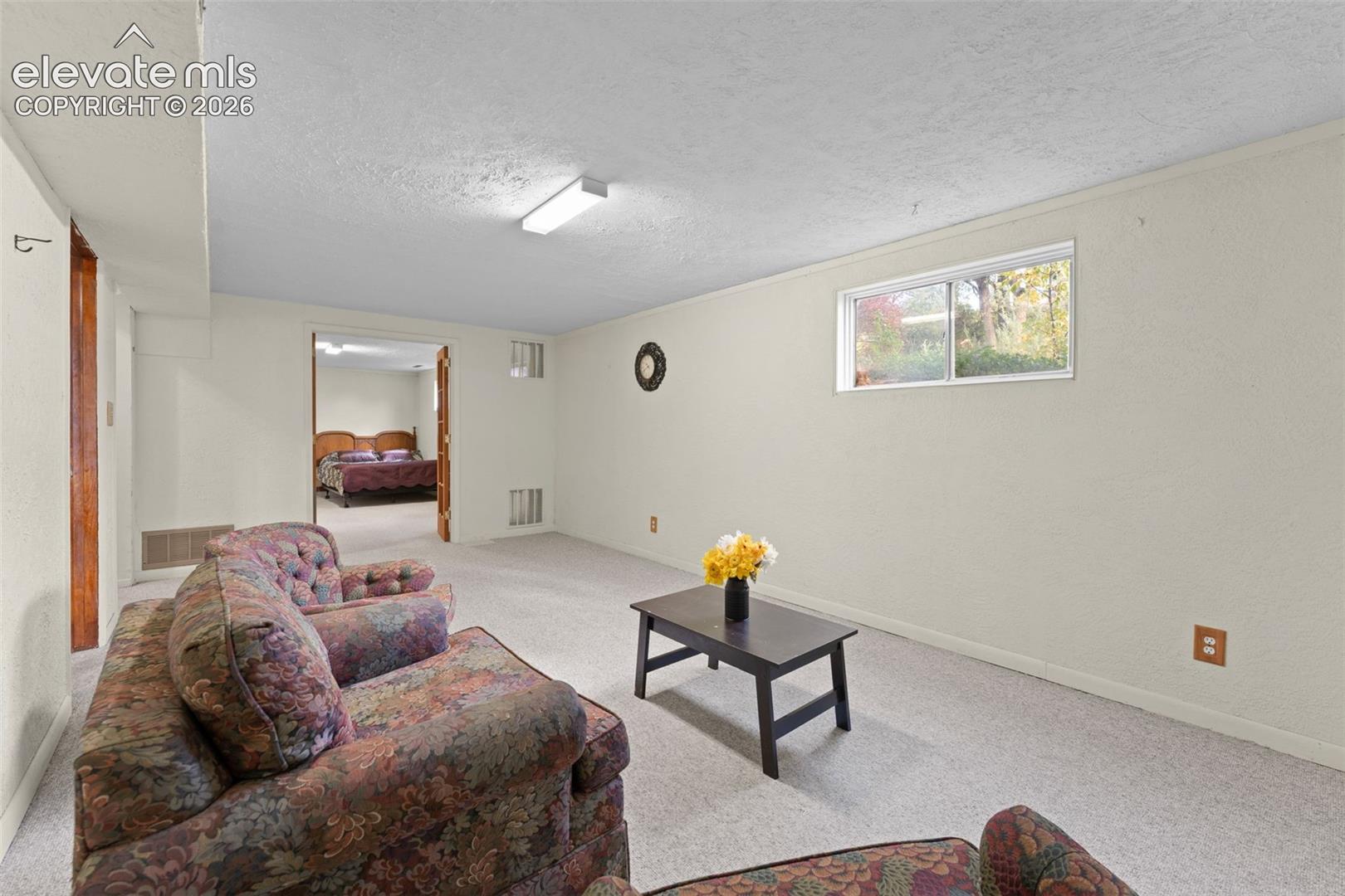 Carpeted room featuring a double-hung window, recessed lighting, and a doorway to an additional room