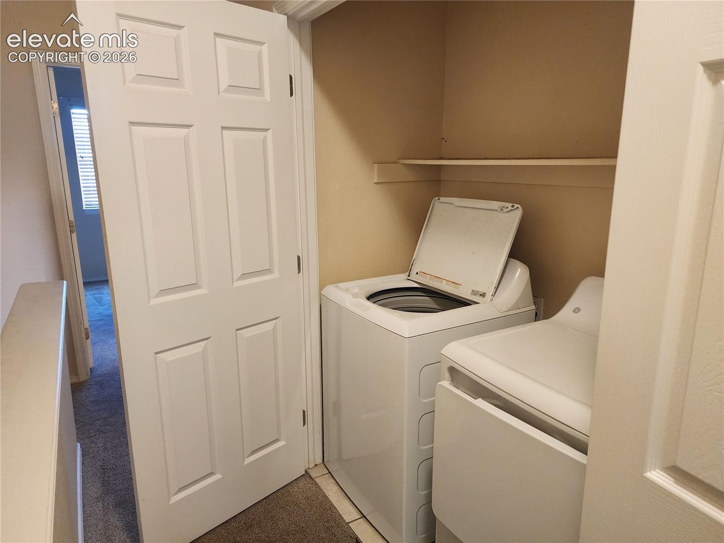 Upper level Dedicated laundry closet with built-in shelving