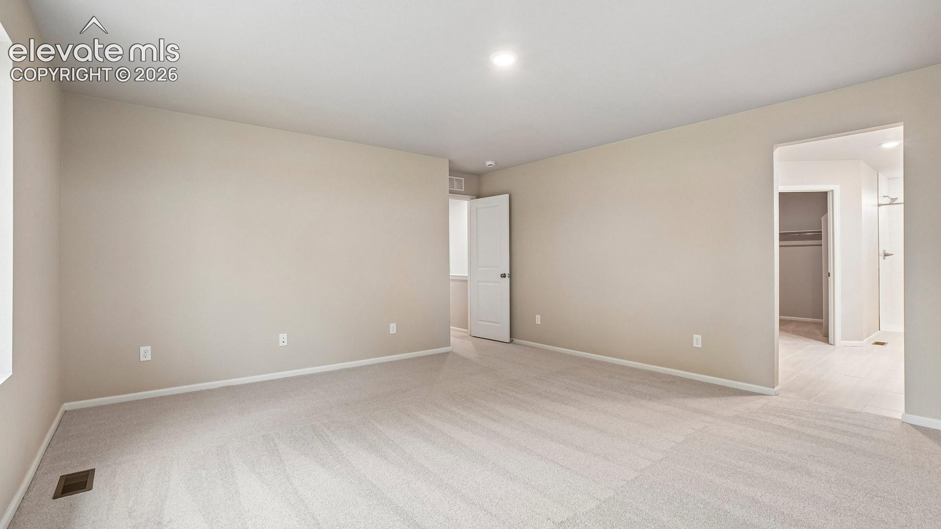 Expansive room featuring neutral wall tones, recessed lighting, and soft carpeting
*photos of a model home*
