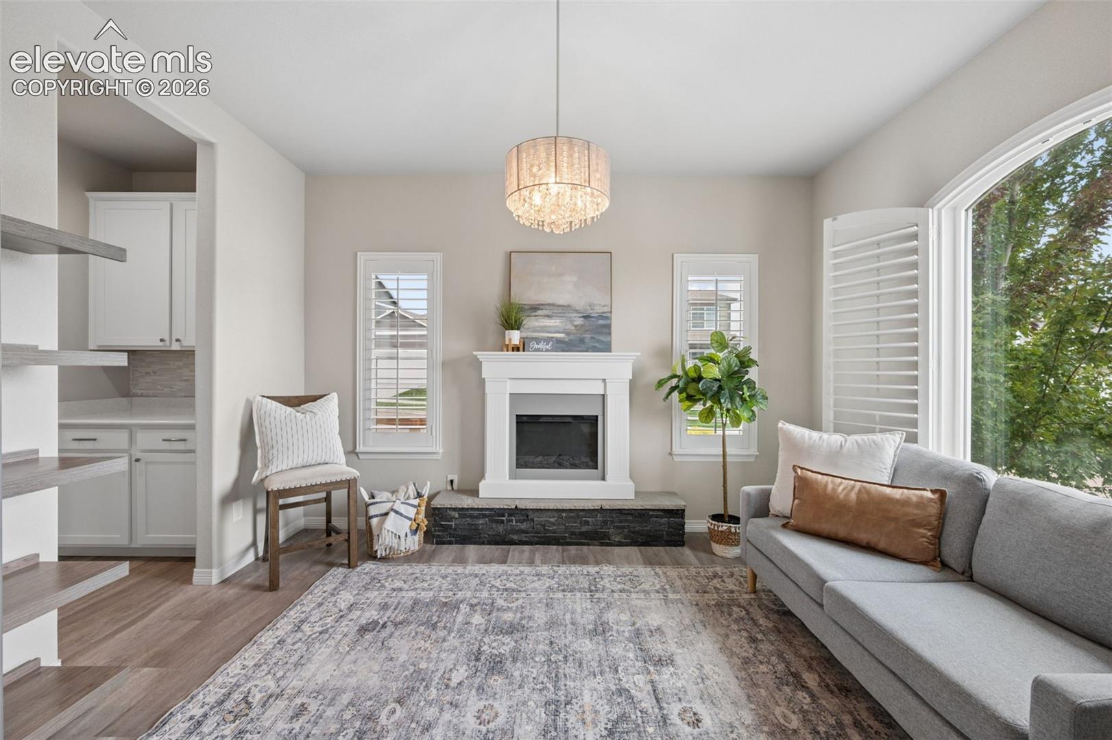 Wood-finish flooring throughout, featuring a fireplace with stone hearth