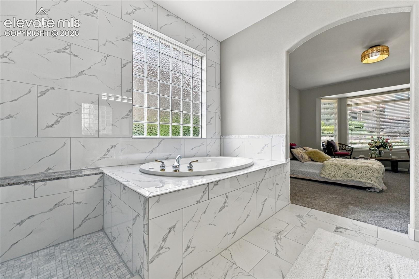 primary suite adjoining luxury ensuite with new tile throughout
