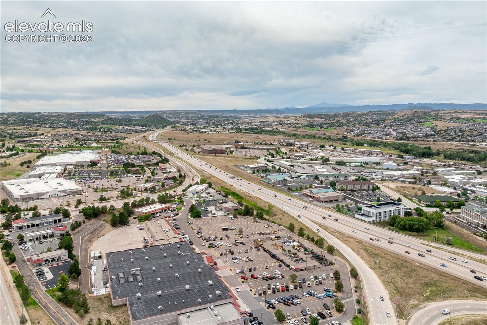 Aerial perspective highlighting commercial corridor proximity to major thoroughfare and expansive terrain
