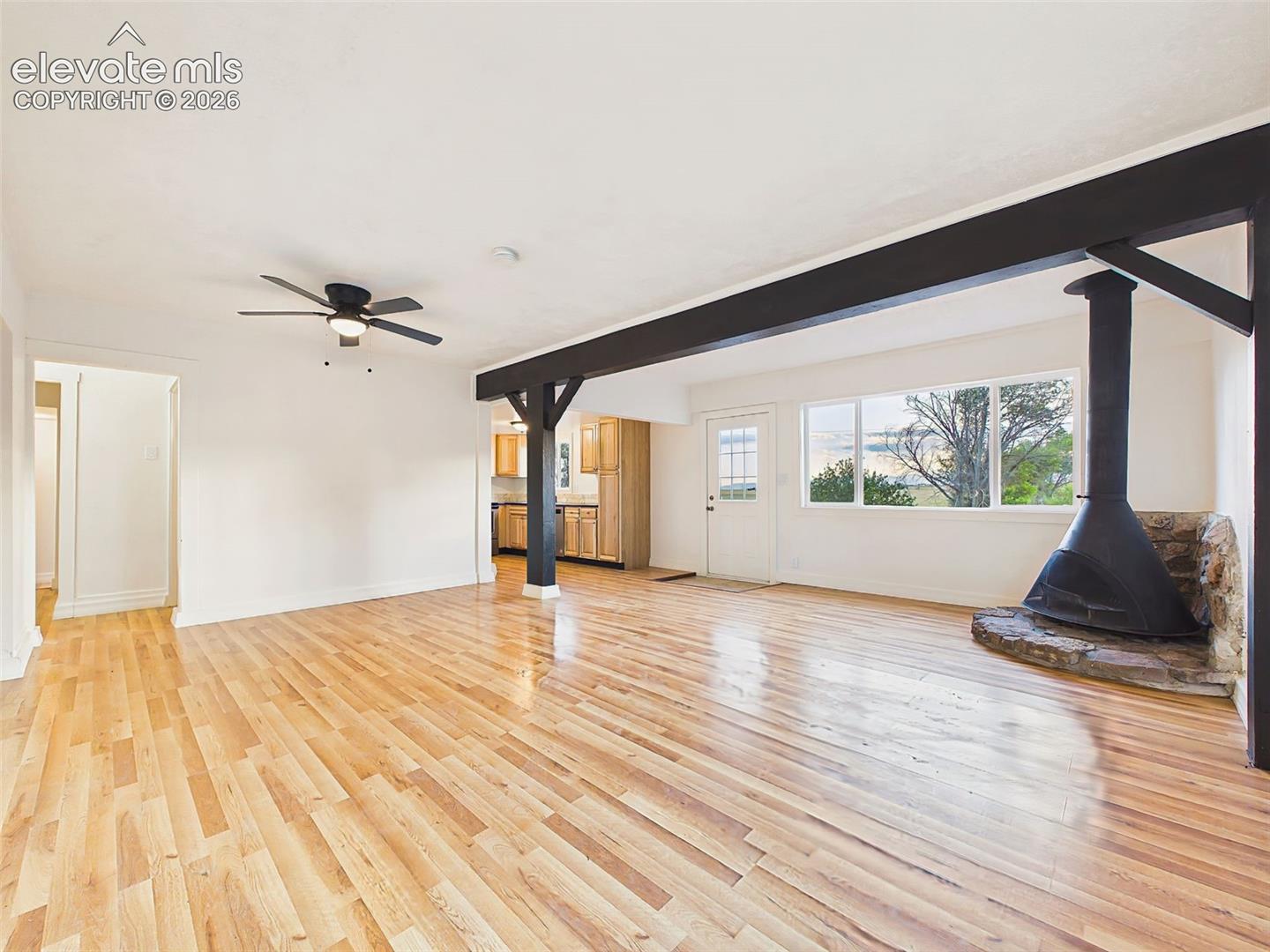 Great Room – Architectural beam details add character to this bright, open gathering space filled with natural light from oversized windows.