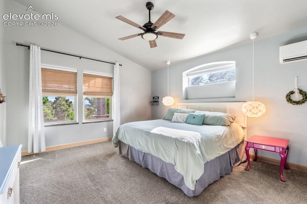 Vaulted ceiling with a ceiling fan, dual windows, arched transom window, and wall-mounted climate control unit