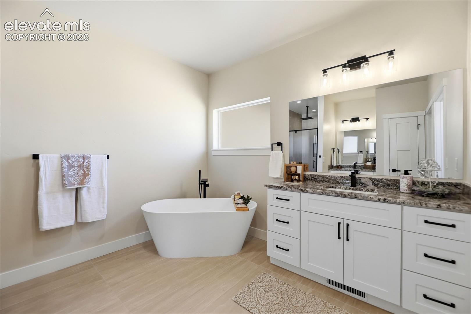 Soaking tub, double separate vanities, walk-in shower with bench