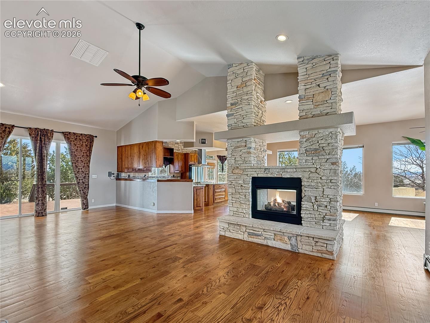 Cozy fieplace and entrance to wide open deck for entertaining or relaxing