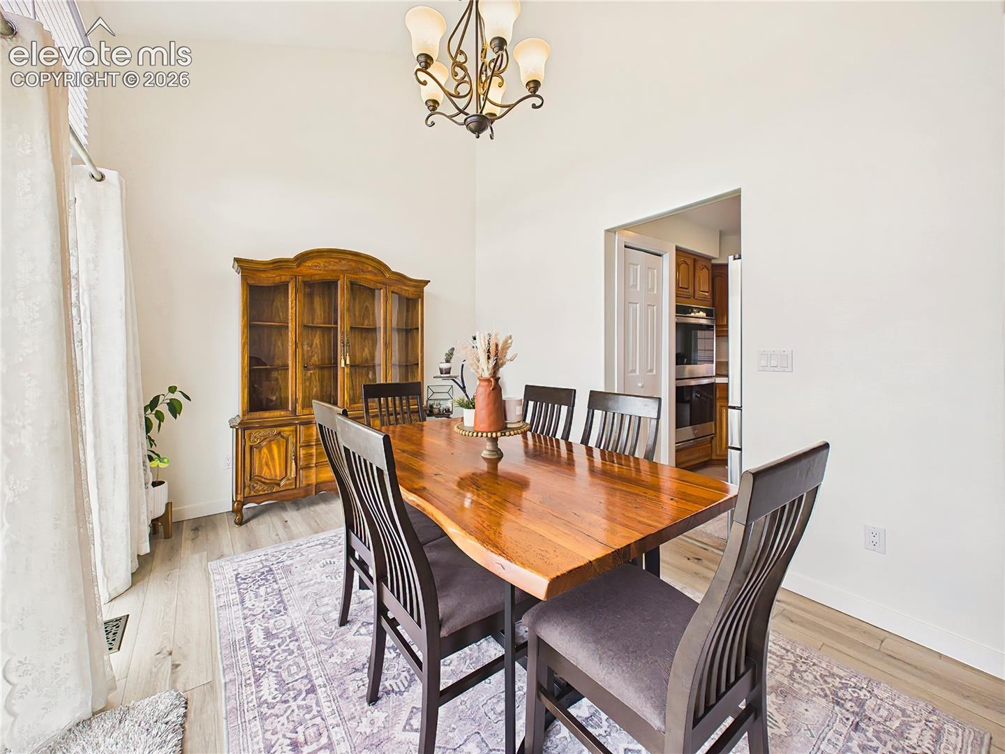 Vaulted ceilings and updated flooring create an airy atmosphere, while the generous dining space is ideal for everyday meals and special gatherings.