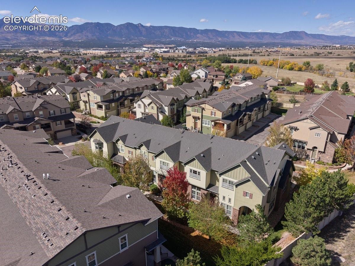 Aerial perspective of multi-story residential structures featuring composite shingled roofing, varied exterior siding, and mountain backdrops