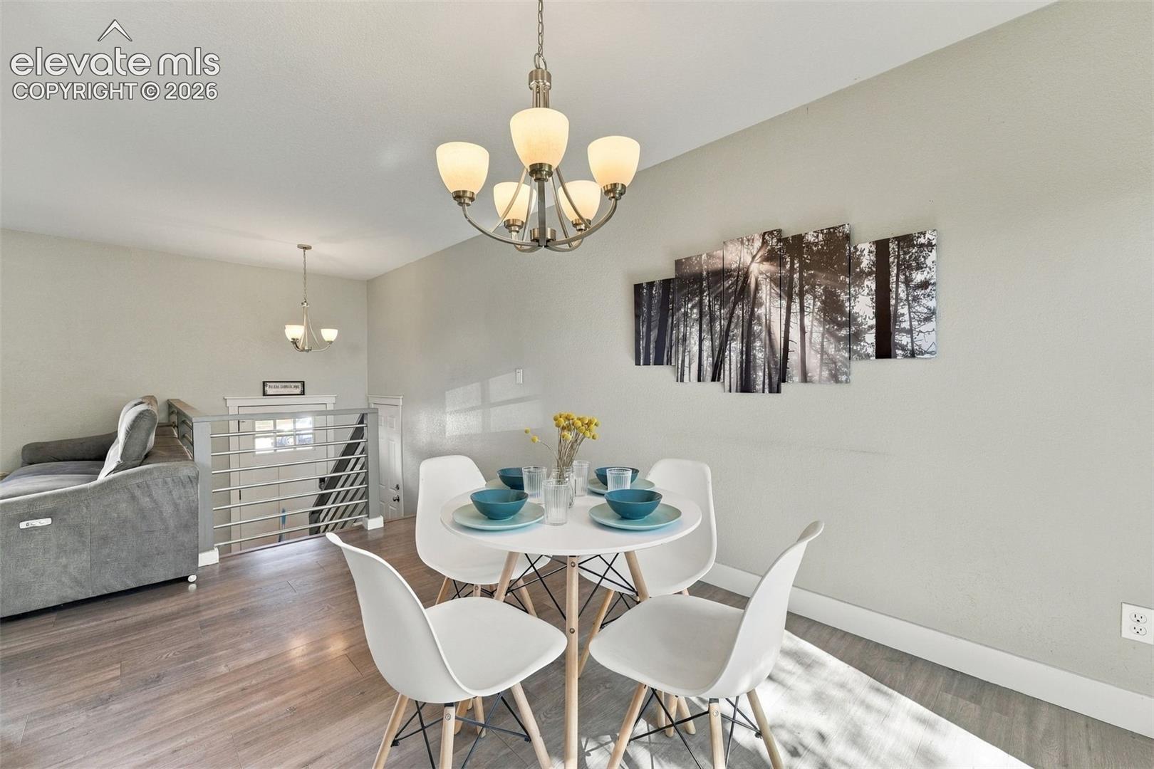 Wood-finish flooring throughout, complemented by a contemporary chandelier and a second pendant light fixture