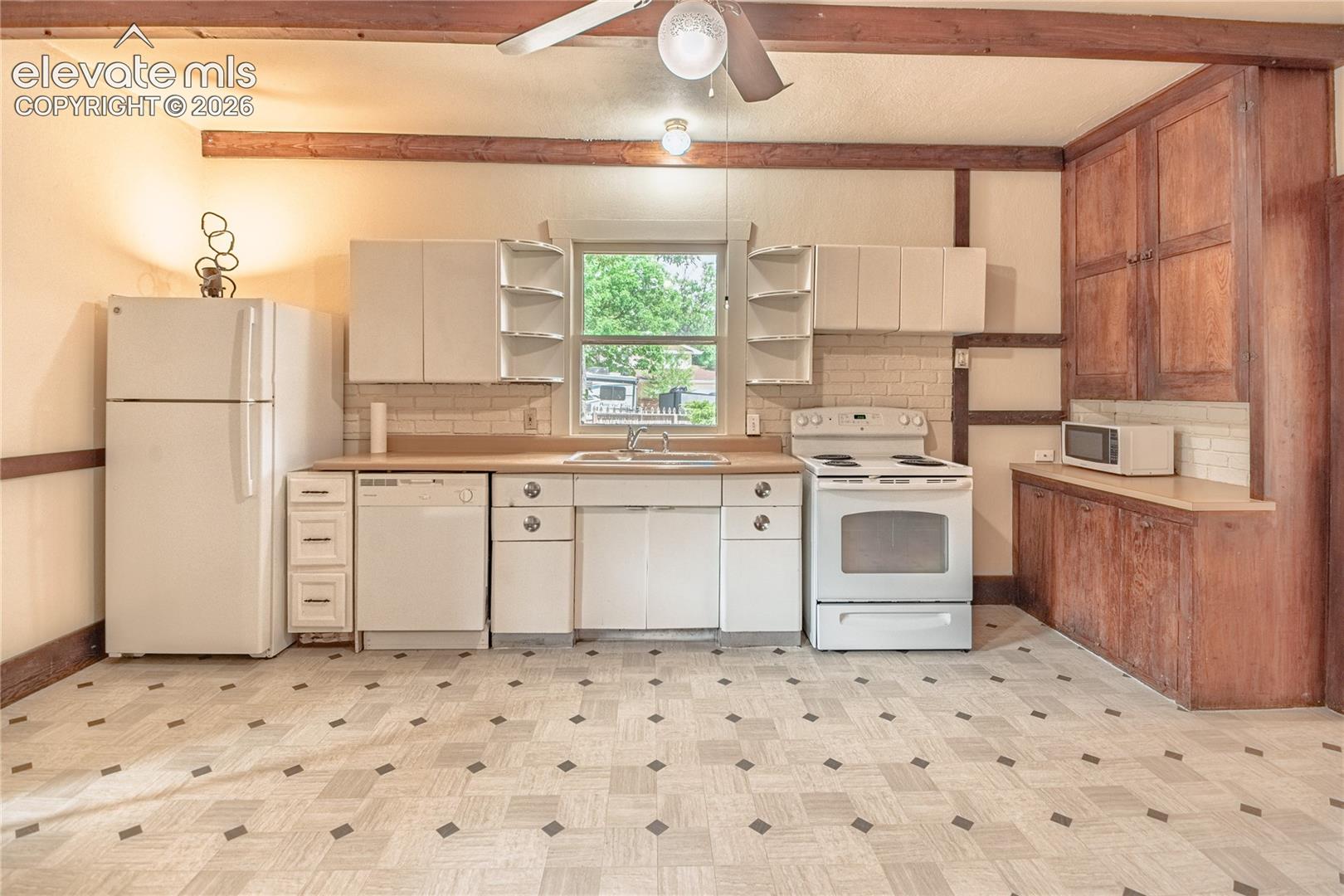Kitchen featuring white cabinetry, wood-finish countertops, tile backsplash, and exposed wood ceiling beams