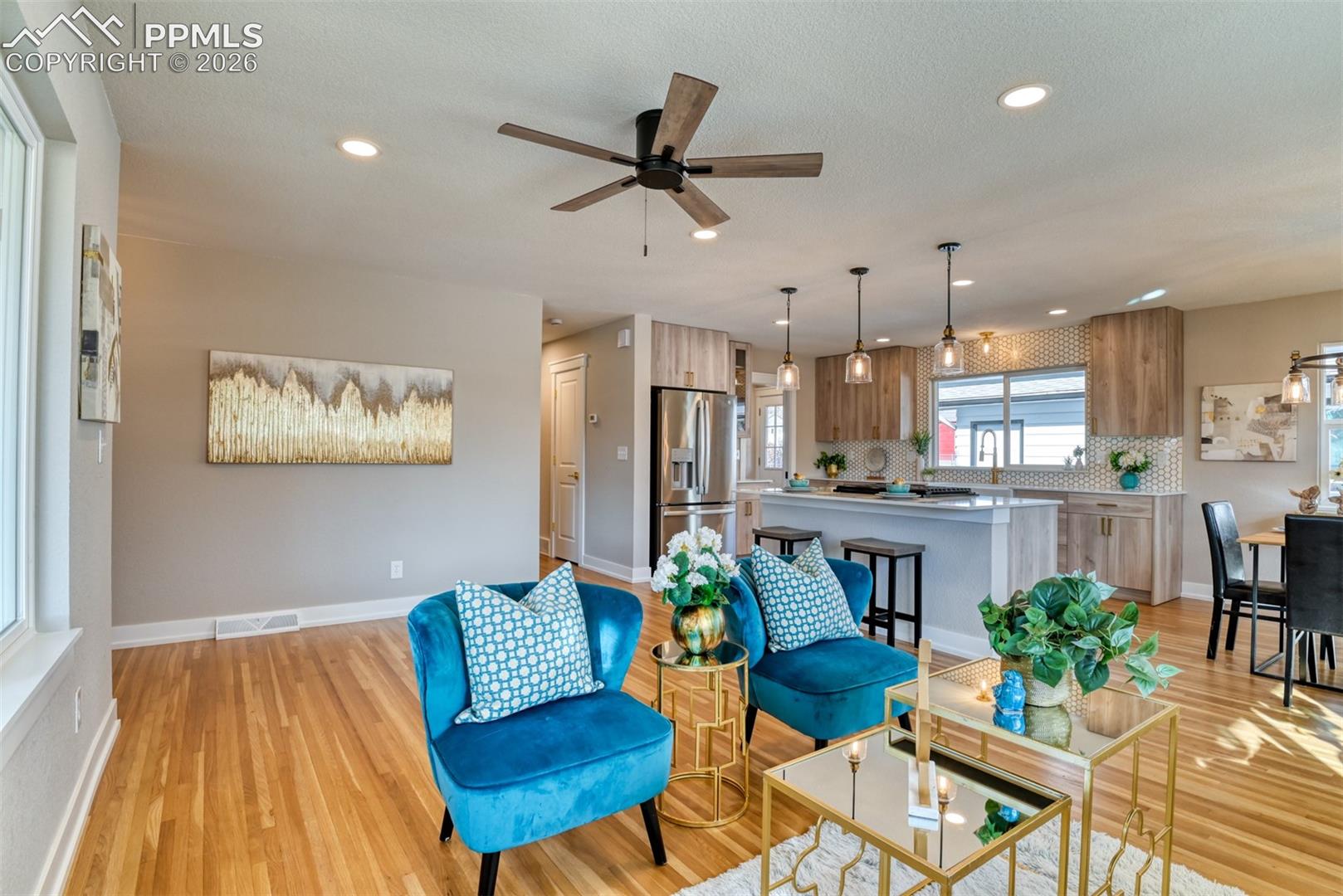 Living area with a ceiling fan, light wood finished floors, and recessed lighting