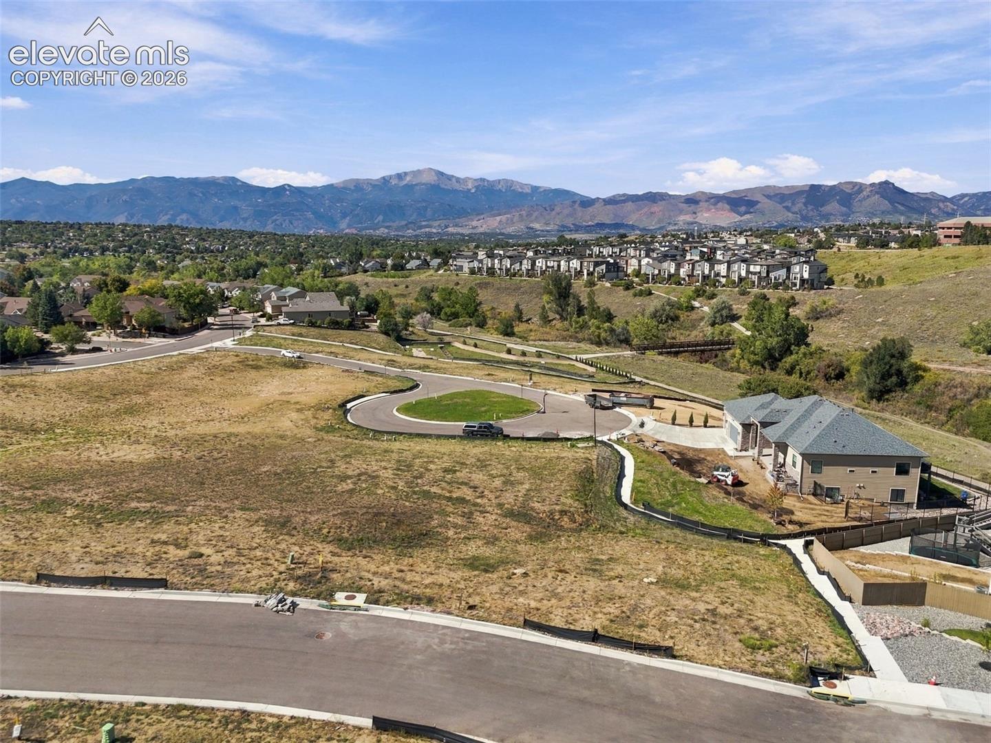 Mountain backdrop and expansive open space surrounding a newly constructed residence