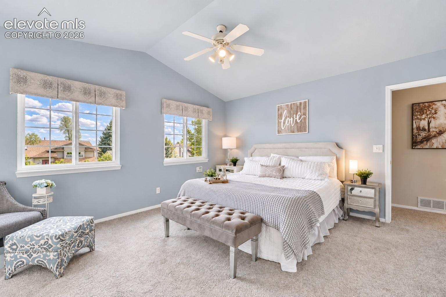 Upper Level Primary Bedroom with neutral carpet, lighted ceiling fan, adjoining bathroom, and walk in closet.