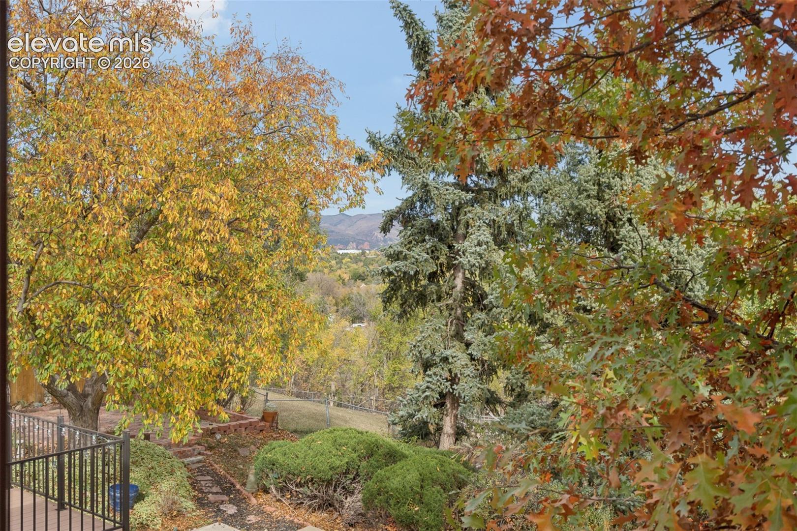 Back yard is fully fenced and features views of city lights, mountains and Garden of the Gods from the walkout patio off the lower level family room.