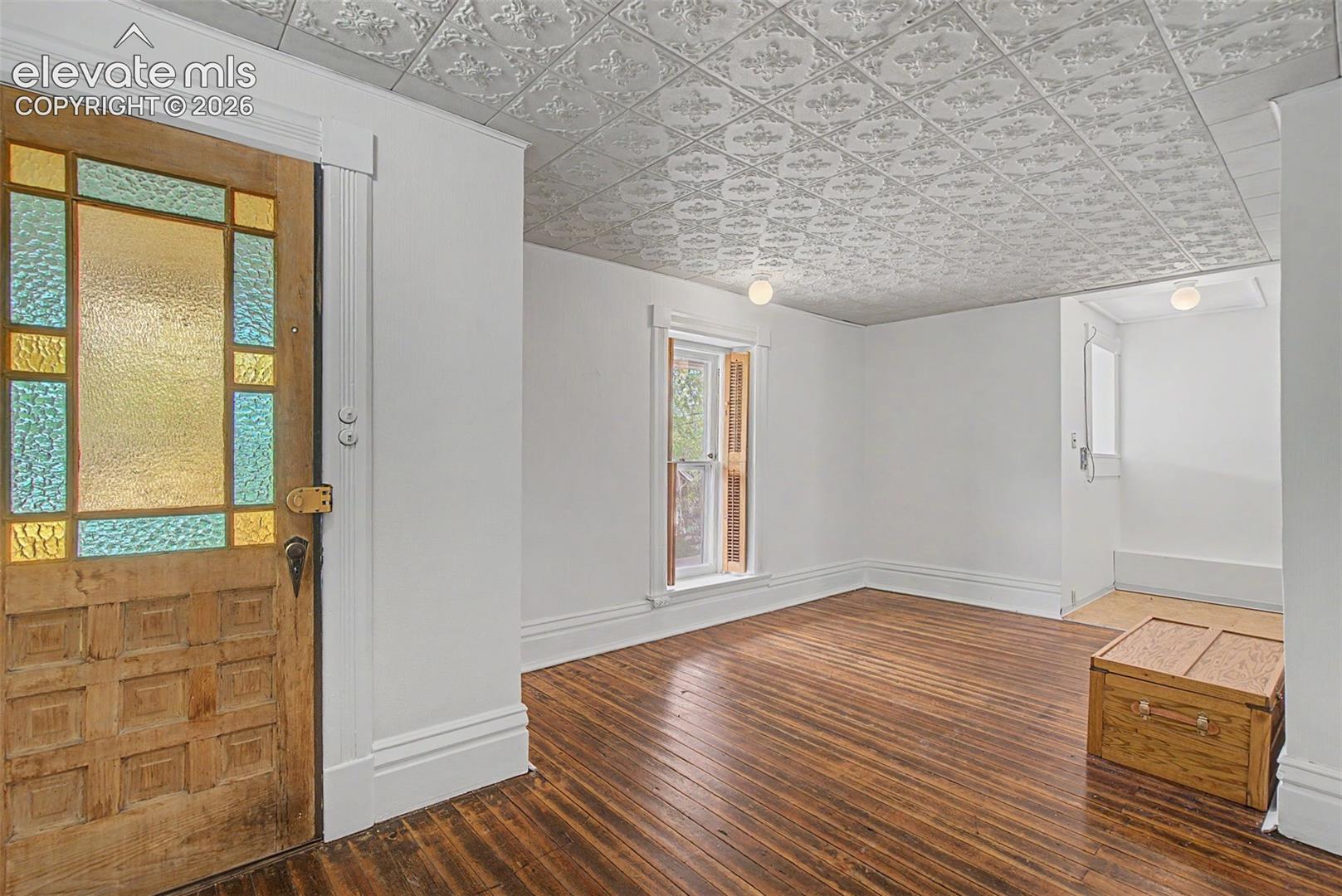 Secondary suite entrance featuring hardwood flooring and open concept to dining room and kitchen