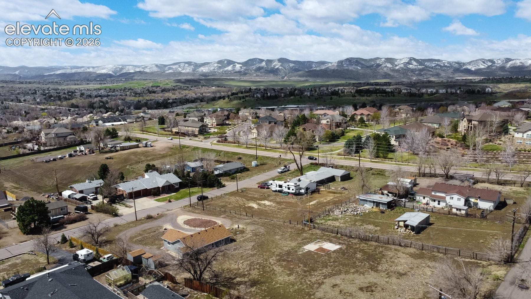 Aerial perspective of expansive lot featuring mountain range backdrop and mature trees