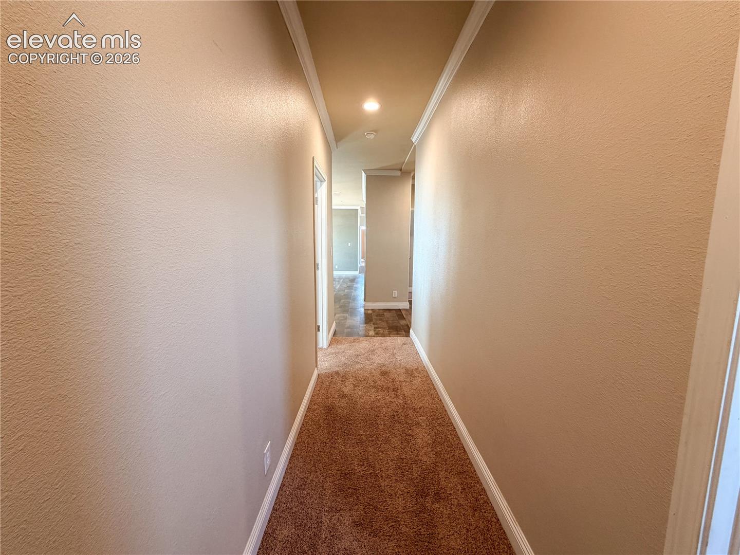 Interior hallway featuring wall-to-wall carpeting, recessed lighting, and crown molding