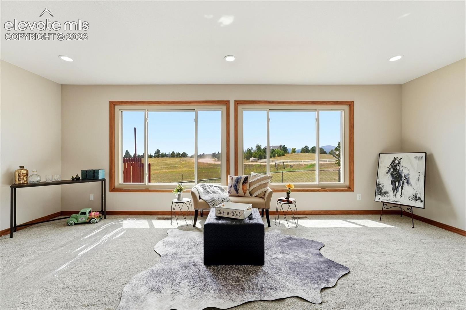 Recessed lighting, light-toned walls, and wood-trimmed windows