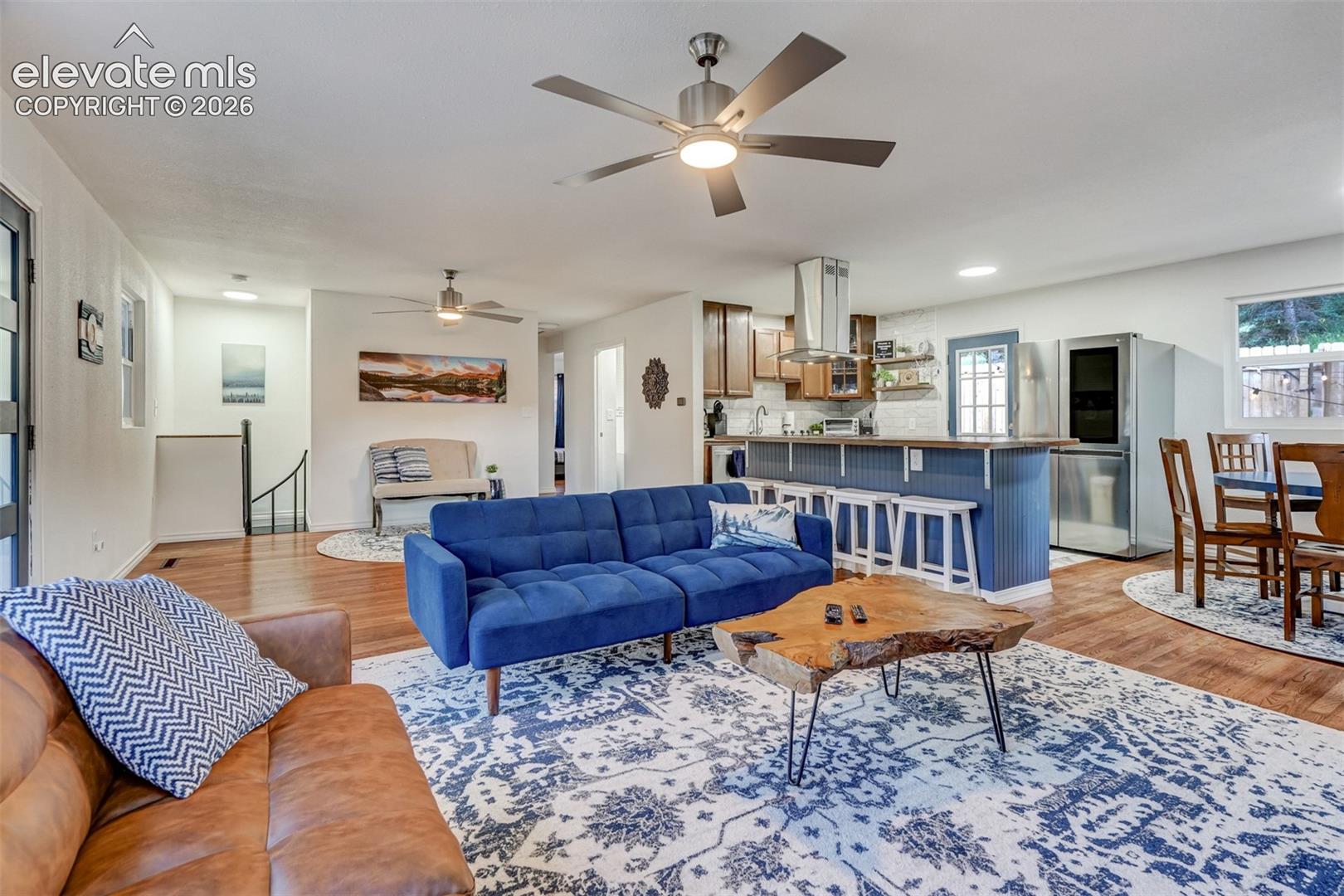 Open-concept living space featuring wood-finish flooring, recessed lighting, and ceiling fans