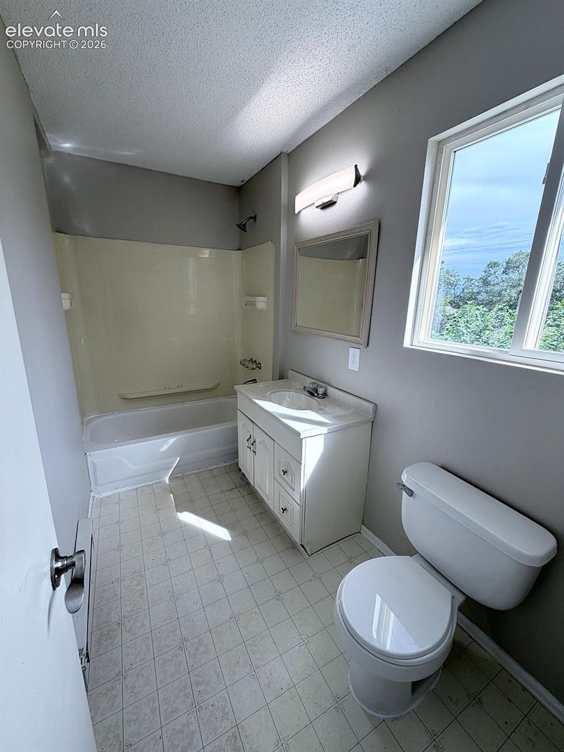 Bathroom with a single vanity, integrated sink, and white cabinetry