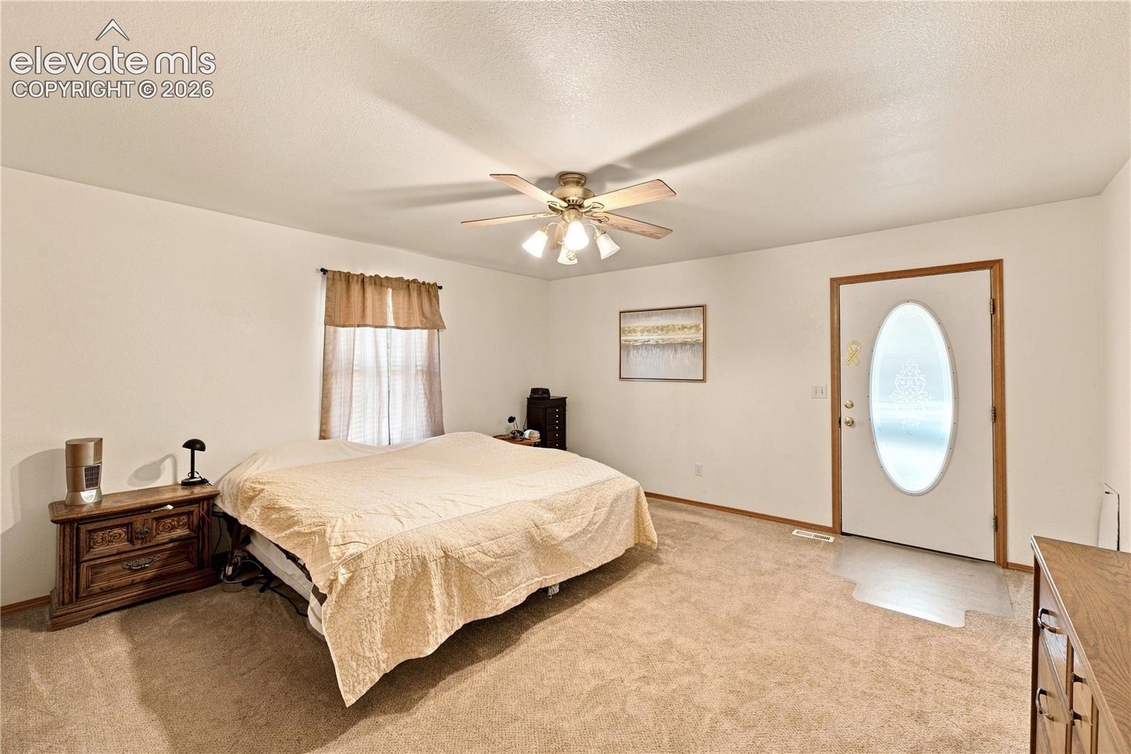 Carpeted room with a ceiling fan