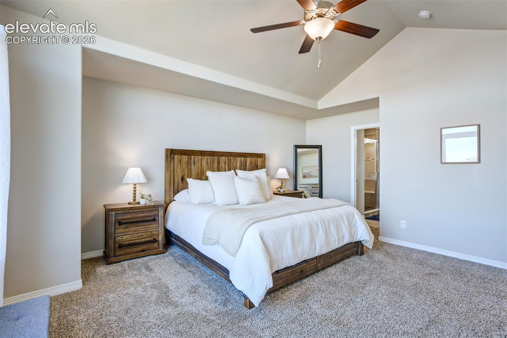 Tray ceiling, ceiling fan, carpet flooring, recessed wall niche, and an open doorway