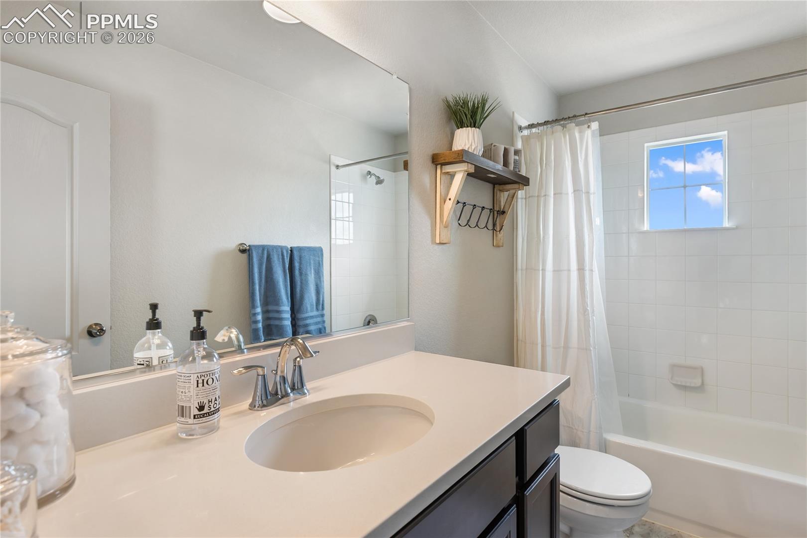 Bathroom featuring a single vanity with an integrated sink, polished chrome faucet, and a dark wood-finish cabinet