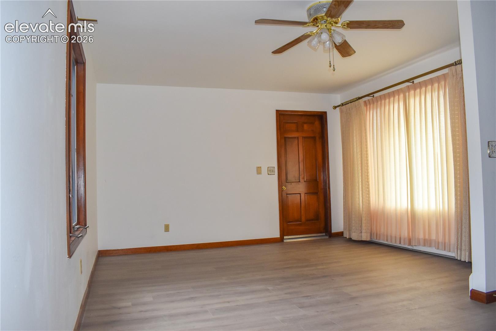 Wood-finish flooring, white walls, and a paneled wood door