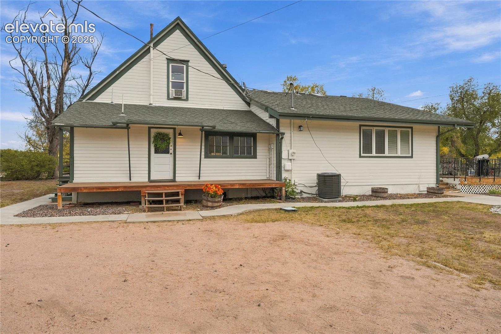 Rear view of home, back covered porch and private Primary deck