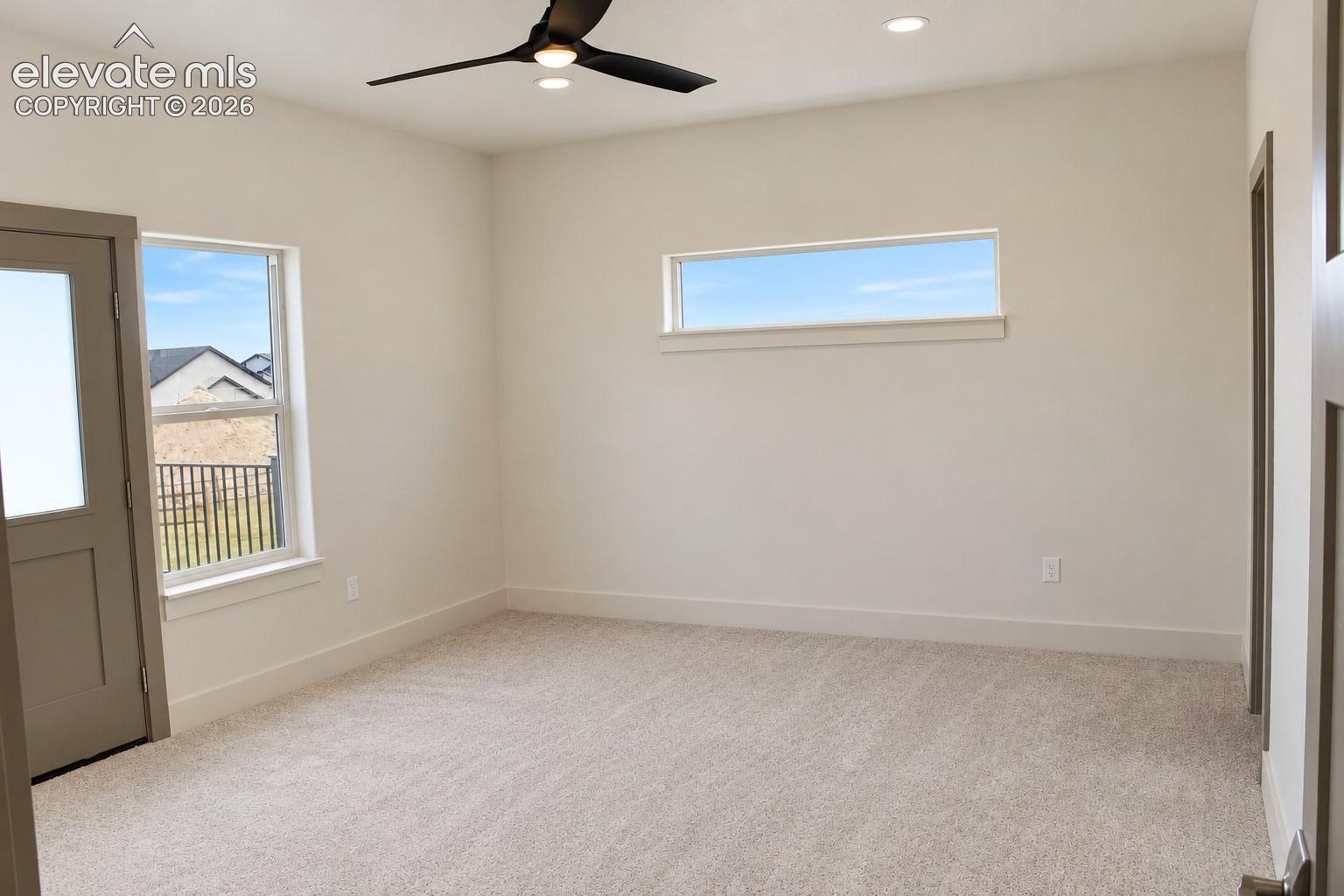 Neutral-toned carpeting, recessed ceiling lighting, and a modern ceiling fan