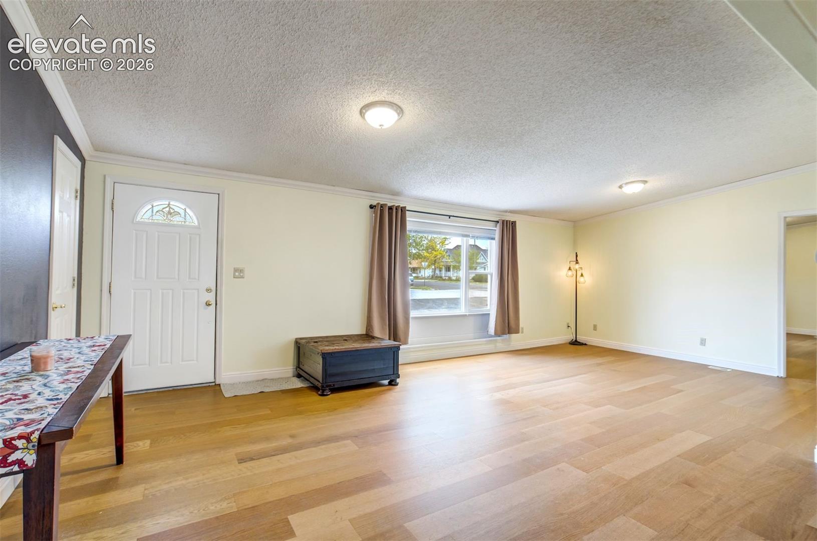 Bright living room with large front window allowing natural light in.
