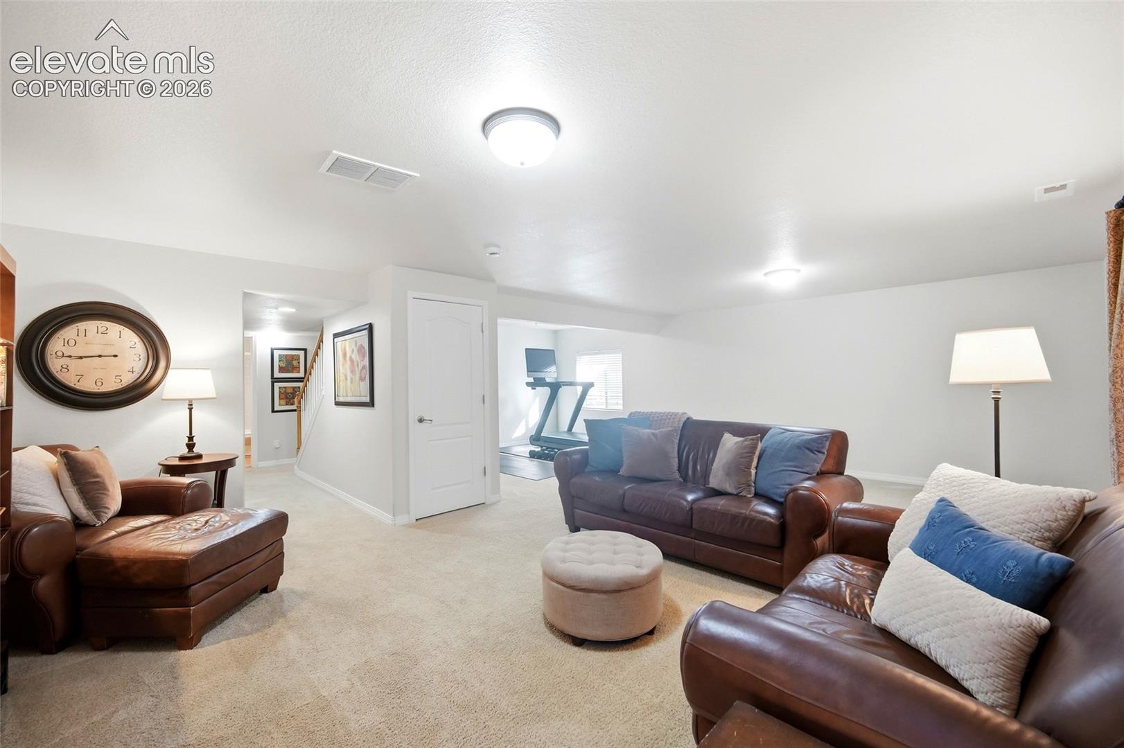 Neutral-toned carpeting spans the floor, complemented by bright white walls and ceiling