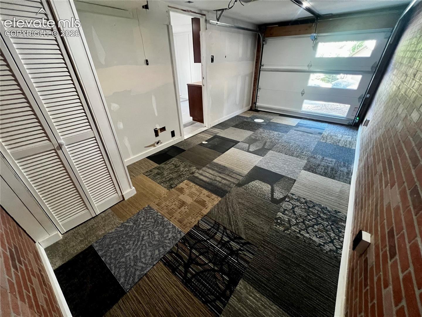 Lower Apt: View of heated garage and/or bedroom/LR. New garage door.