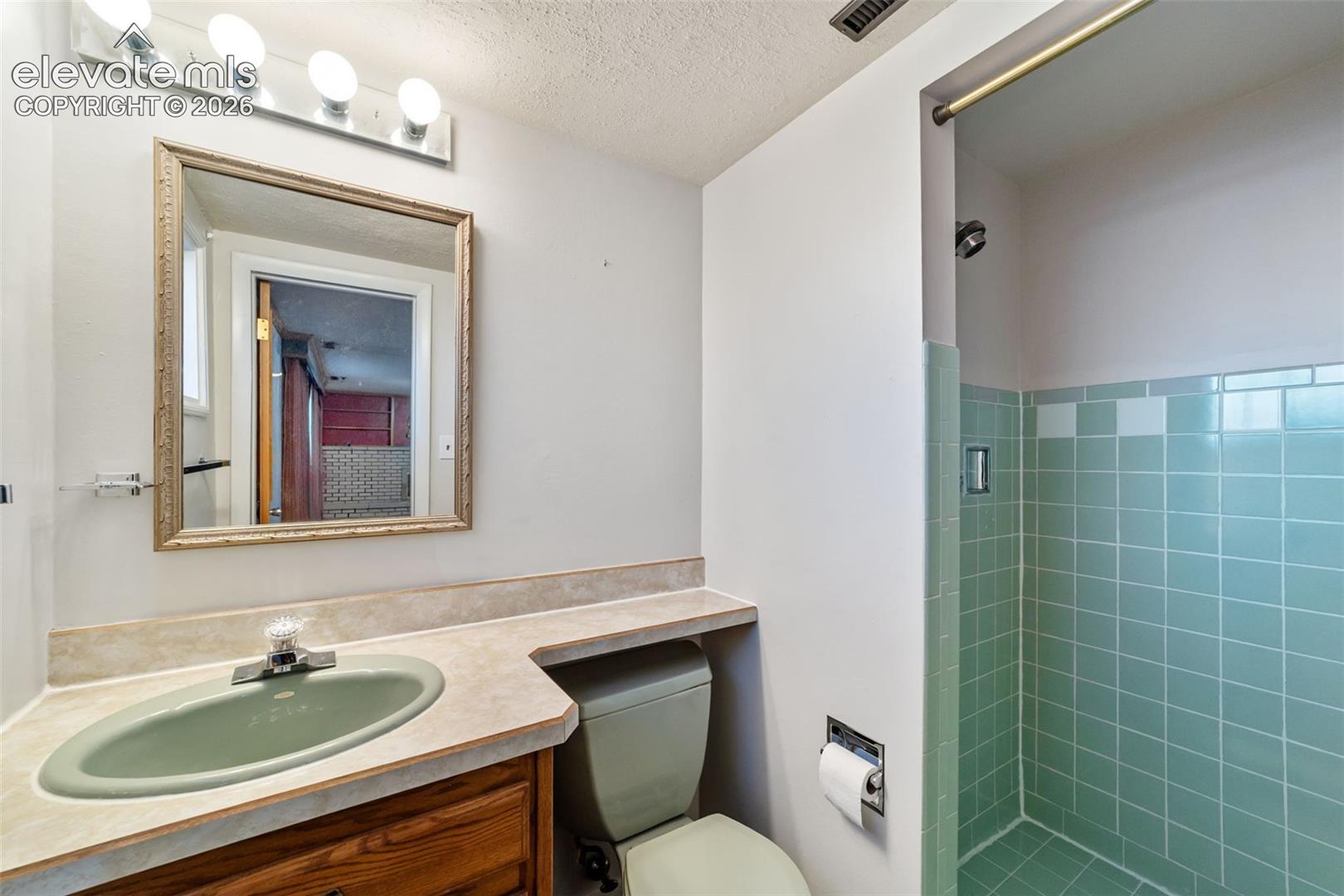 Bathroom featuring a built-in wood-finish vanity with an integrated sink and light-toned countertop
