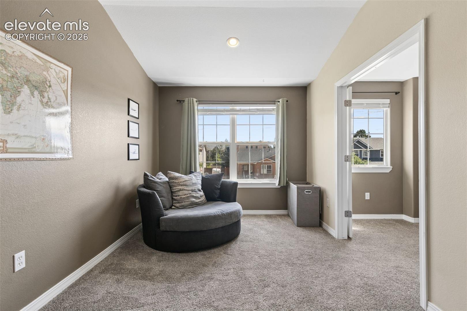 Carpeted room with neutral wall tones and a ceiling-mounted light fixture