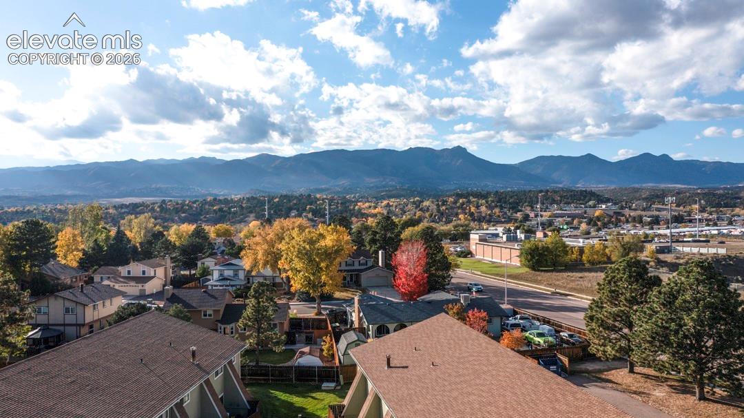 Aerial perspective featuring residential structures and a prominent mountain range backdrop