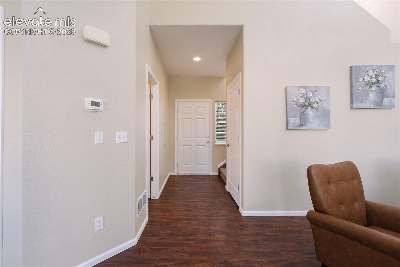 Entryway featuring vaulted ceilings, wood-finish flooring, and a multi-panel front door with sidelight window