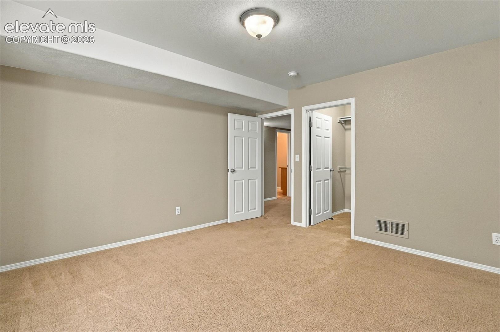 Carpeted flooring, neutral wall tones, white trim, and a semi-flush mount ceiling light