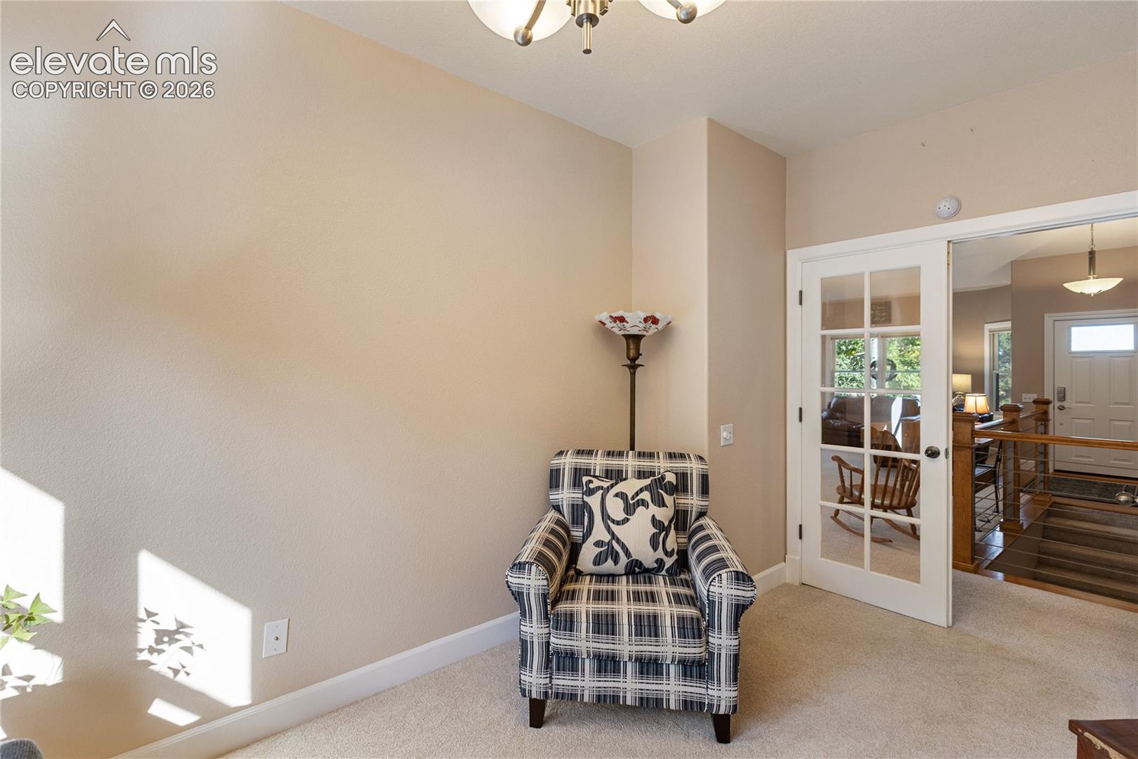 Carpeted flooring, neutral wall tones, white trim, and a white French door