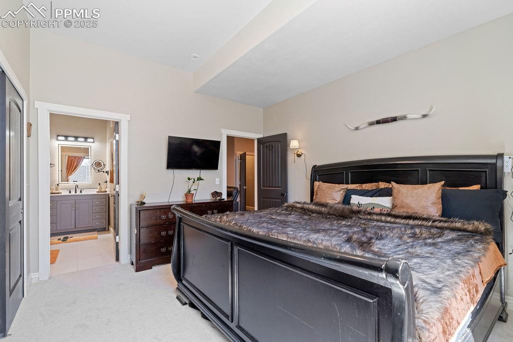 Bedroom with light colored carpet and light tile patterned flooring