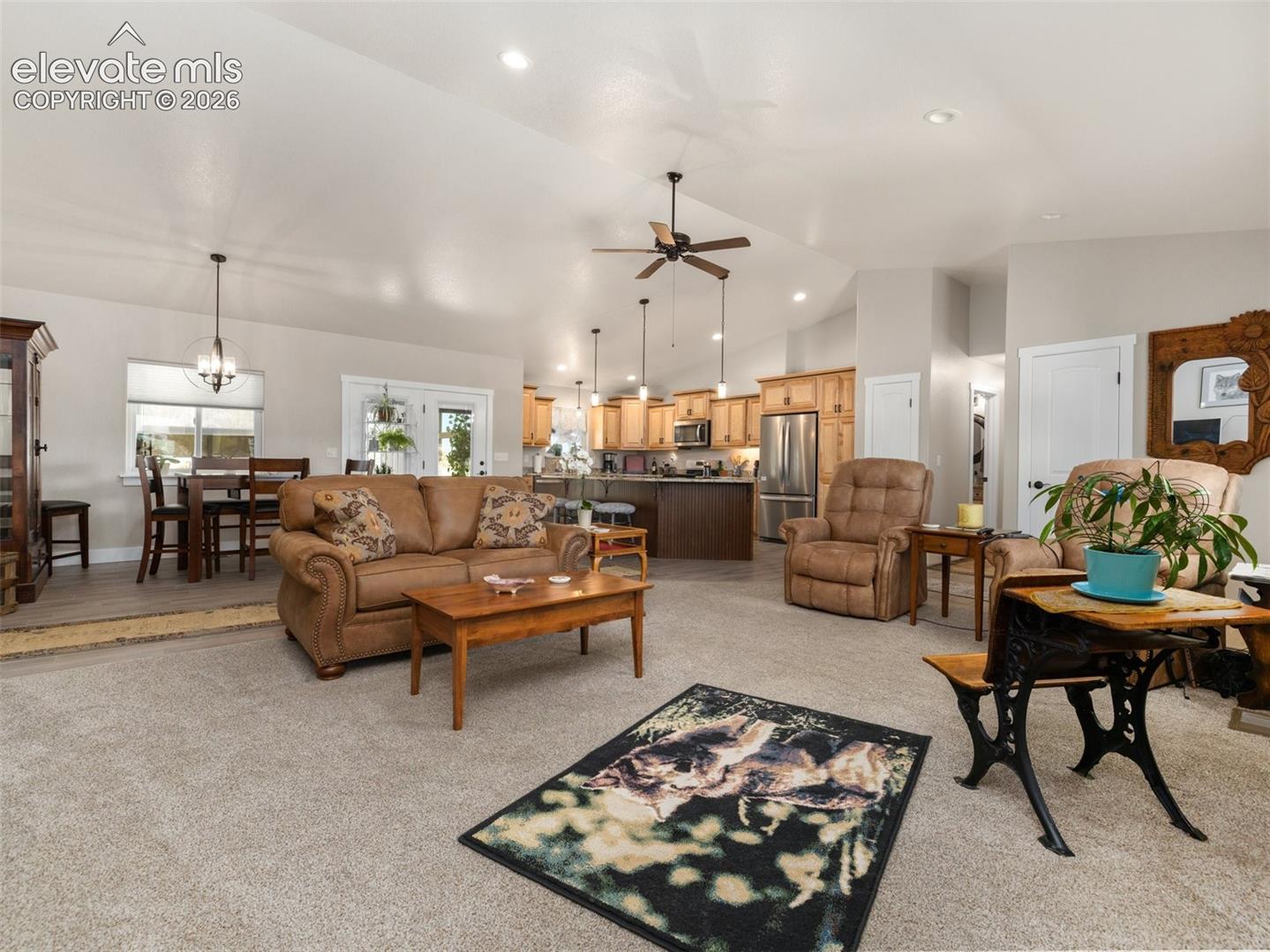 Open-concept living space with vaulted ceilings, recessed lighting, and a ceiling fan