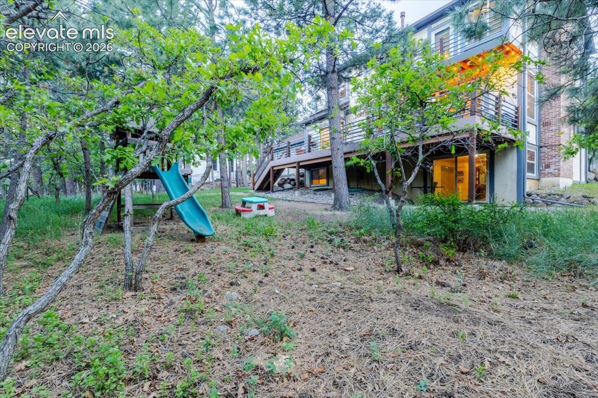 Expansive wooded backyard featuring mature trees, a multi-level deck, and a walk-out lower level with sliding glass doors