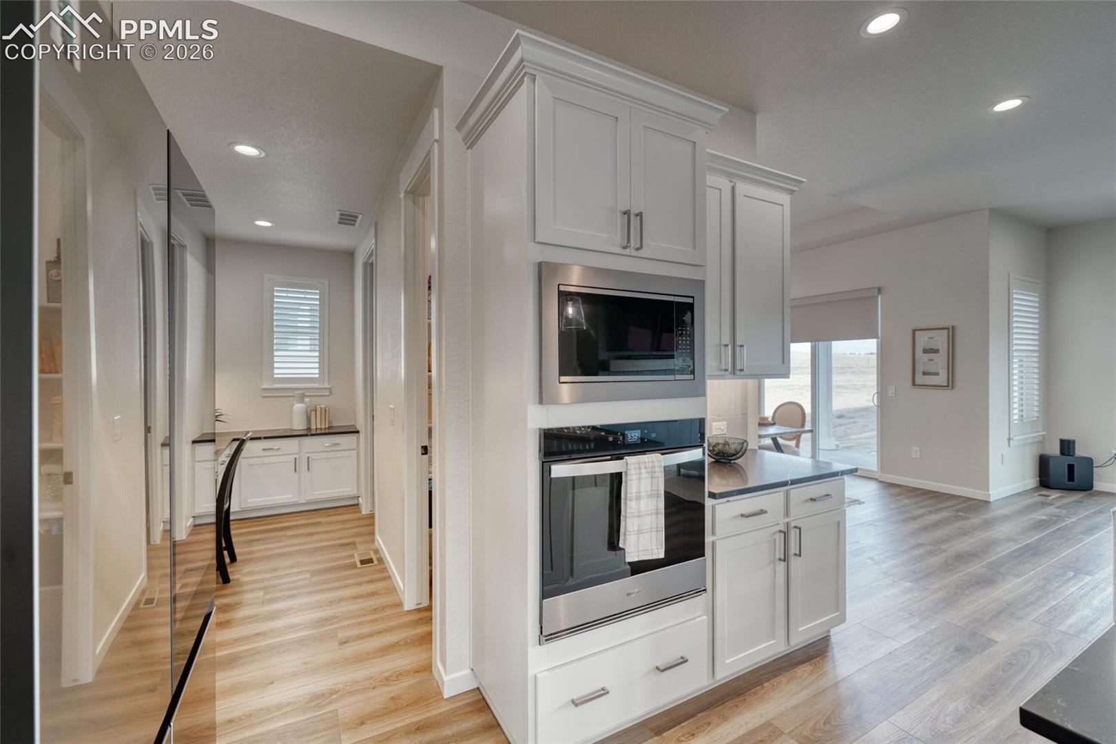 Kitchen featuring white cabinetry, stainless steel appliances, light wood-type flooring, and recessed lighting