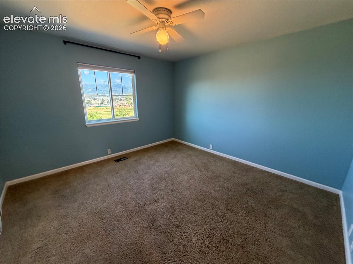 Window with white trim, brown carpeting, and a ceiling fan with integrated lighting