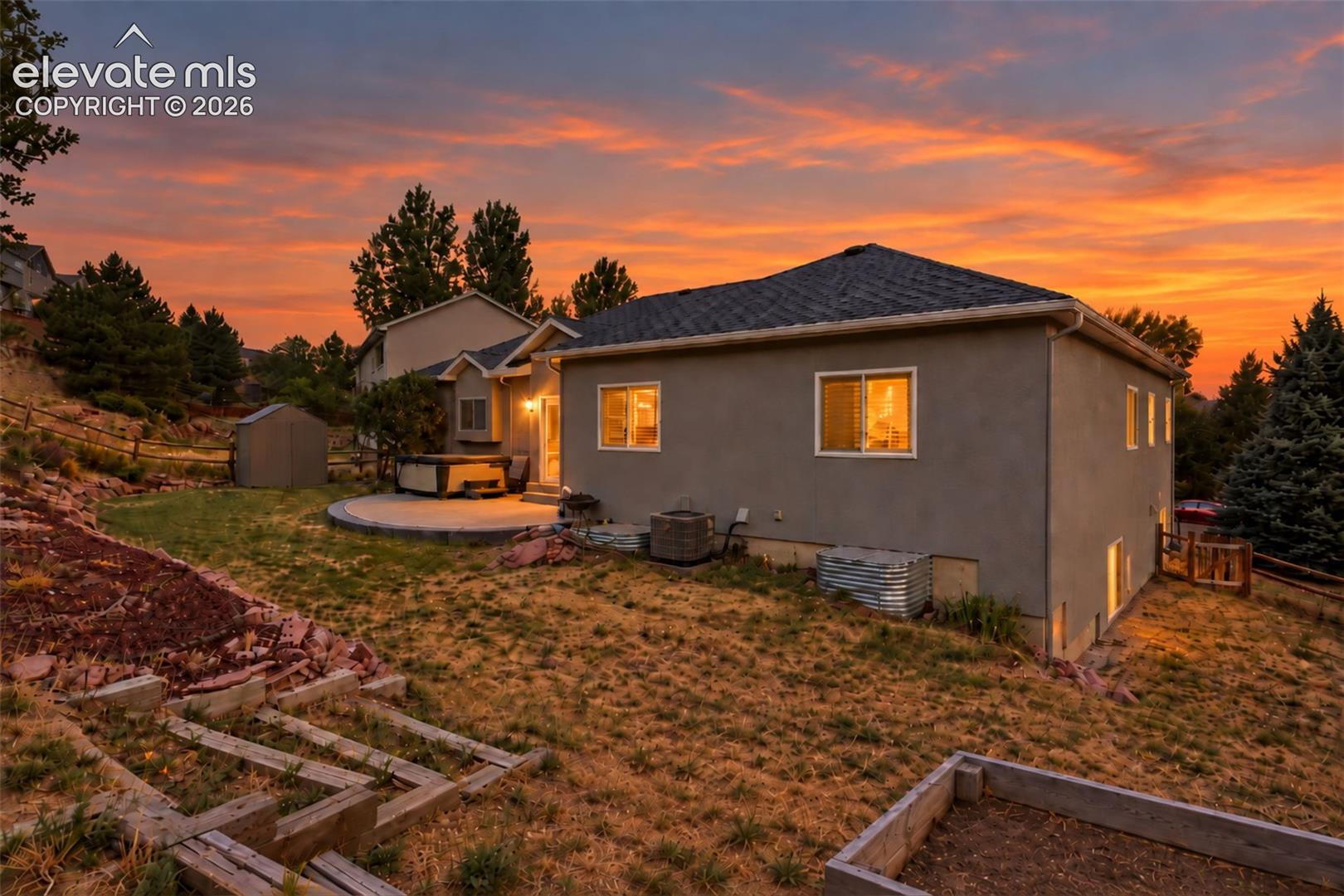 Rear exterior with concrete patio, hot tub, and detached storage shed