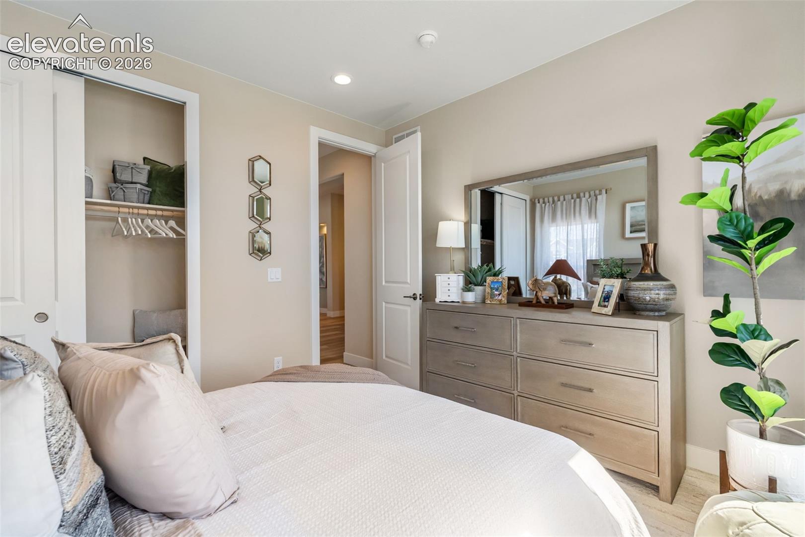 Neutral-toned walls, recessed lighting, and a reach-in closet with integrated shelving