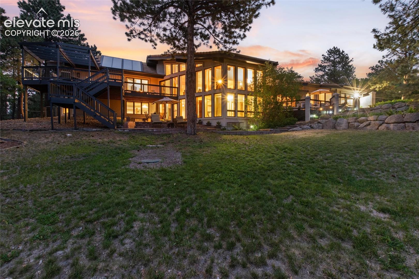 Multi-level dwelling with extensive fenestration, multiple outdoor entertaining areas, and a lower-level patio