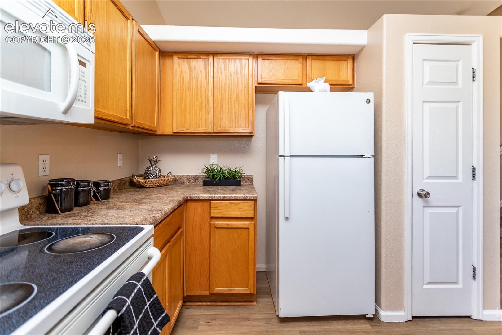 Enjoy cooking in this efficient kitchen layout fitted with warm oak cabinets and an electric range hood setup
