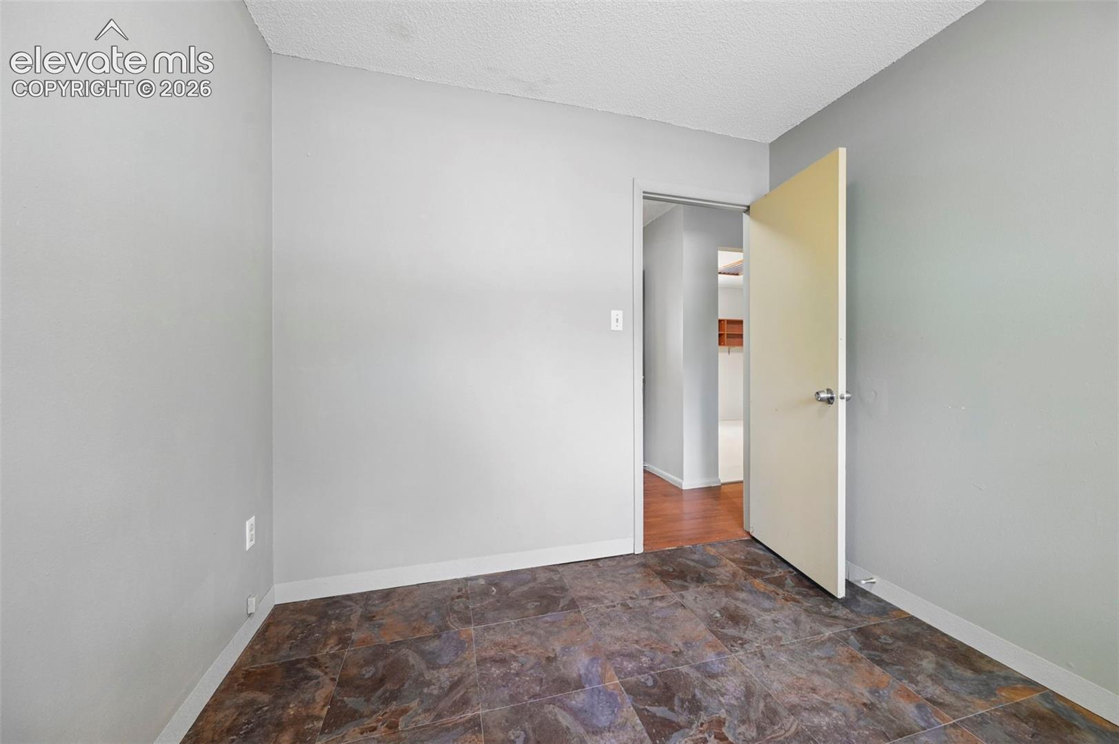 Room featuring neutral gray walls and multi-toned tile flooring