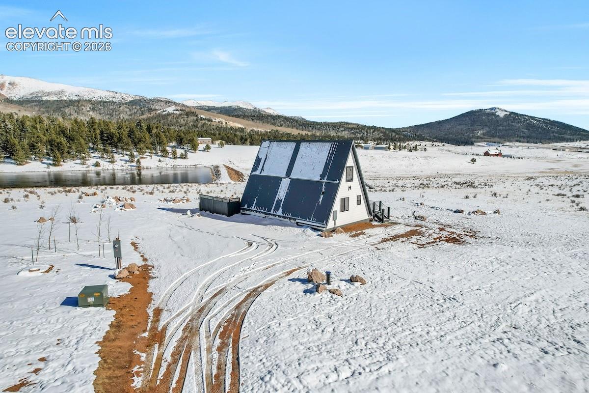 A-frame structure featuring a metal roof, white siding, and mountain backdrop
